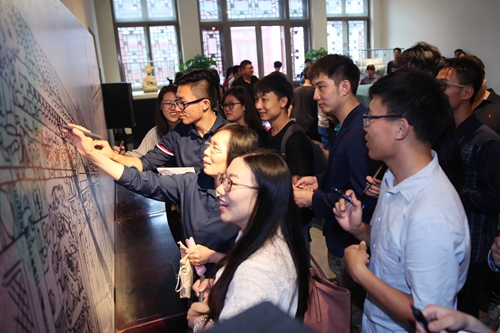 师生在留言墙上涂画和签名